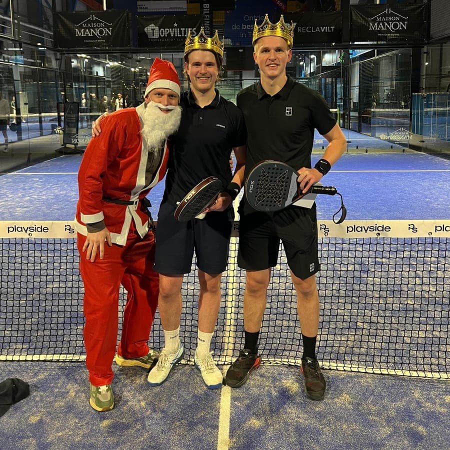 Twee spelers met kroontjes naast de kerstman, bij het net op een baan van Playside