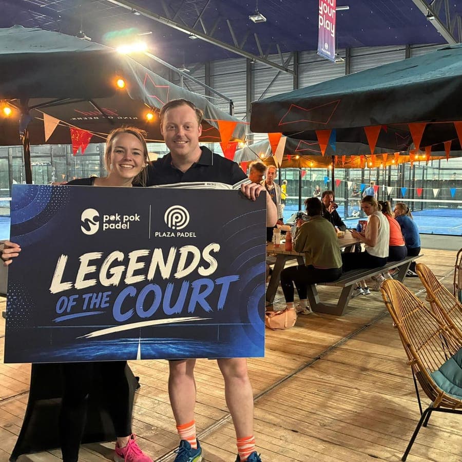 Een speelster en een speler met het bord Legends of the Court van Pok Pok Padel en Plaza Padel
